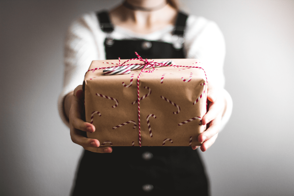 Woman giving a wrapped gift.