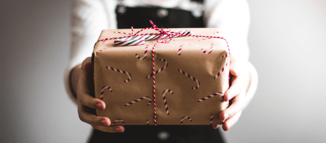 Woman giving a wrapped gift.